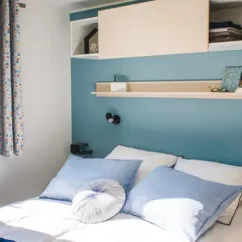 Chambre Mobil Home Smala 4 Chambres 8 Personnes- Camping La Touesse avec lit et étagères murales