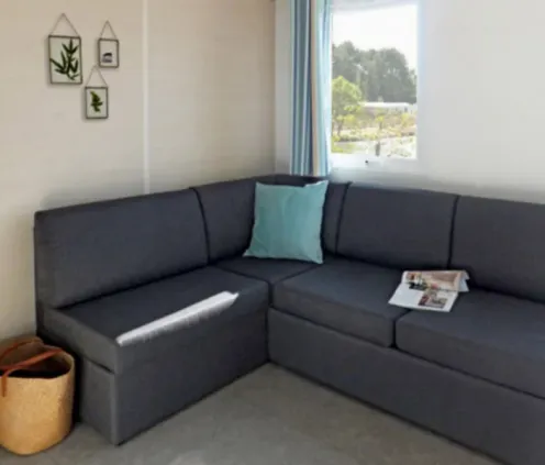 Mobil Home Premium 3 Chambres 6 Personnes 35m² - Camping Paradis de Rhuys : canapé L en tissu gris avec coussin bleu