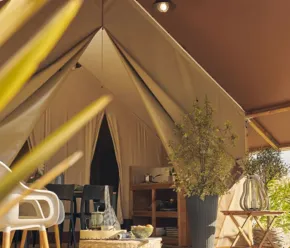 Intérieur d'une tente avec table et plantes - Camping Paradis de Rhuys
