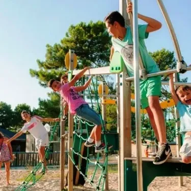 Enfants jouent sur un parc infantile en bois et métal au Camping Atlantique Club Montalivet