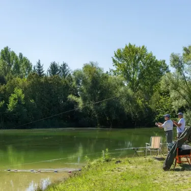 Camping Le Ried : deux pêcheurs sur un lac entouré de forêt.