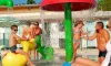 Camping Le Ried : enfants jouent sous une fontaine de jeux aquatiques colorée