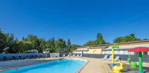 Camping Le Ried : piscine avec chaises longues et jeux aquatiques