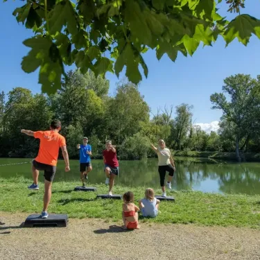 Camping Le Ried : groupe faisant de l'exercice près d'un lac