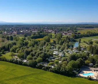 Vista aérienne du Camping Le Ried entouré de forêts et de champs verts.