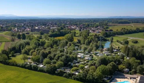 Vista aérienne du Camping Le Ried entouré de forêts et de champs verts.