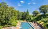 Piscine au Camping Parc des Roches entourée de verdure