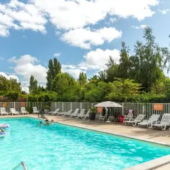 Photo Camping Les Fontaines : piscine avec chaises longues et parasols