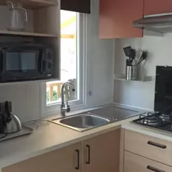 Mobil Home Comfort 3 Chambres 6 Personnes - Camping Ty Nadan : cuisine équipée avec micro-ondes et évier