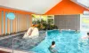 Piscine intérieure avec toboggan et baigneurs au Camping Paradis L'Arada Parc