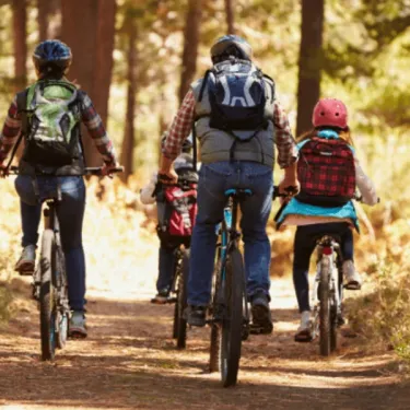 Famille à vélo dans la forêt au Camping Paradis L'Arada Parc