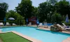 Piscine avec toboggan et chaises longues au Camping des Bains