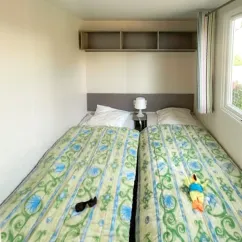Mobil Home Essentiel 2 Chambres 4 Personnes - Camping Paradis L'Arada Parc, chambre avec deux lits et étagères