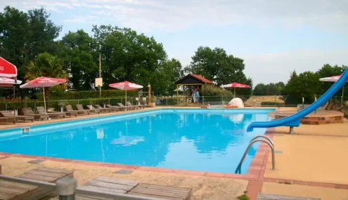 Piscine avec toboggan et chaises longues au Camping Fontaine du Roc