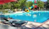 Piscine avec toboggan coloré et chaises longues au Camping Fontaine du Roc