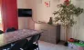 Salle à manger avec table, chaises, télévision et plante - Camping Fontaine du Roc