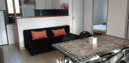Gîte 2 Chambres 4 Personnes - Camping Fontaine du Roc, salon avec canapé et table