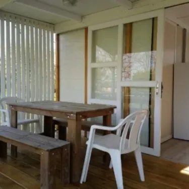 Terrasse du cottage avec table, chaise, portes vitrées