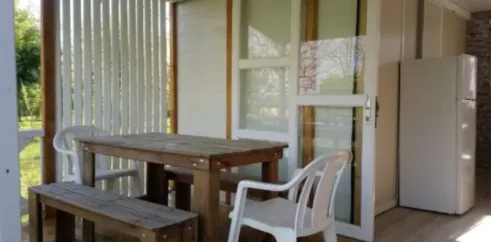 Terrasse du cottage avec table, chaise, portes vitrées