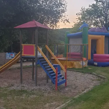 Camping des Bastides - aire de jeux avec toboggan et manège gonflable