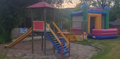 Camping des Bastides - aire de jeux avec toboggan et manège gonflable