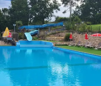 Camping des Bastides - piscine avec toboggan et chaises longues