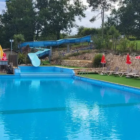 Camping des Bastides - piscine avec toboggan et chaises longues