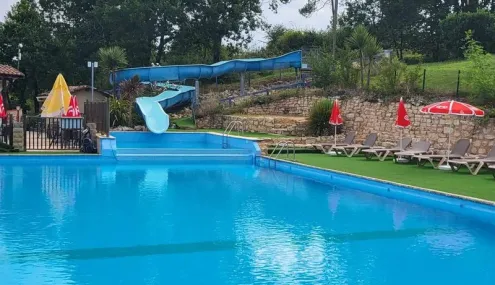 Camping des Bastides - piscine avec toboggan et chaises longues