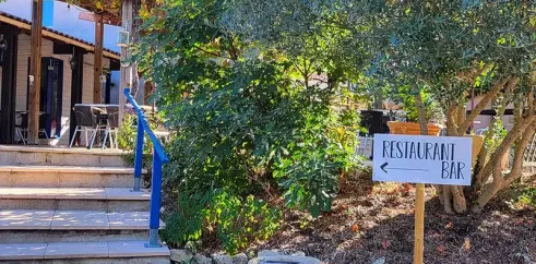 Camping des Bastides - entrée du restaurant bar avec signe et escaliers