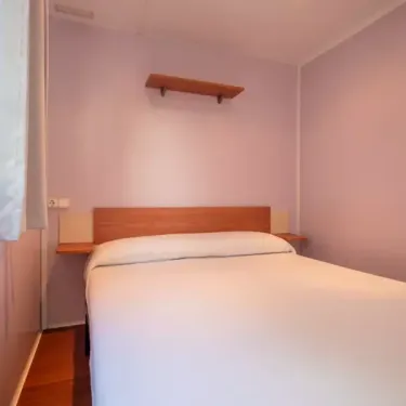Chambre du Mobil Home Aqua Viva avec lit et étagère murale
