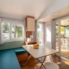 Salle à manger avec fenêtres et accès terrasse du Mobil Home Aqua Viva