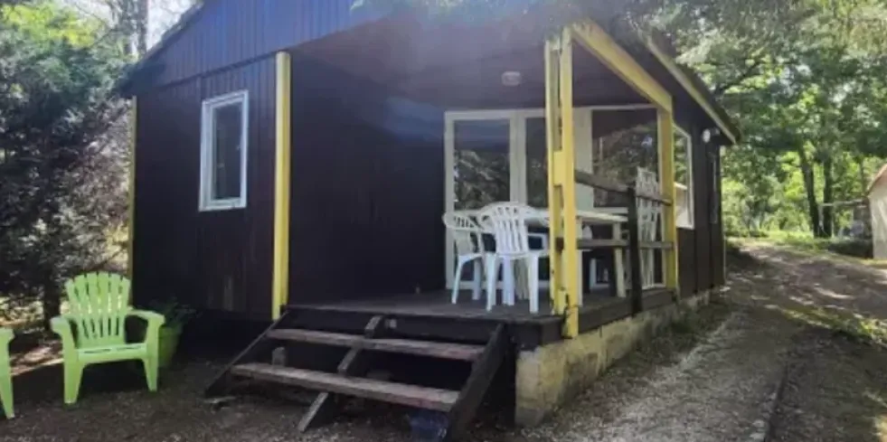 Chalet 2 Chambres 4 Personnes - Camping des Bastides : cabane en bois avec véranda et chaises