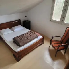 Grand Chalet 3 Chambres 6/8 Personnes - Camping des Bastides : chambre avec lit double, fauteuil et fenêtre