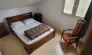 Grand Chalet 3 Chambres 6/8 Personnes - Camping des Bastides : chambre avec lit double, fauteuil et fenêtre
