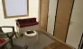 Tithome 2 Chambres 4 Personnes Sans Sanitaires - Camping des Bastides : salon avec canapé, table ronde et tapis en tissu.