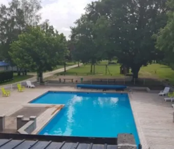 Camping les Naïades : piscine entourée d'arbres et de chaises longues