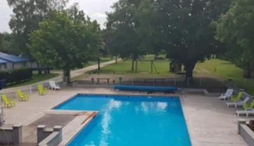 Camping les Naïades : piscine entourée d'arbres et de chaises longues