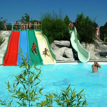Piscine avec toboggans colorés et enfants glissant sur les slides, Camping La Rive