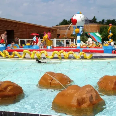 Piscine avec jets et rochers décoratifs au Camping La Rive