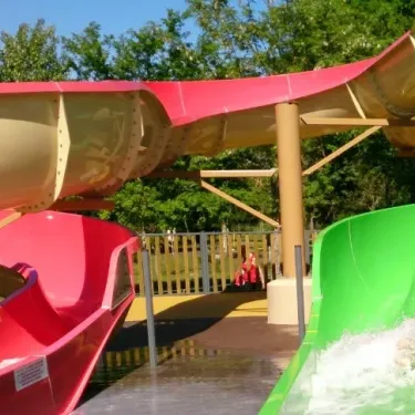 Camping La Rive - toboggan rouge et vert avec eau en mouvement
