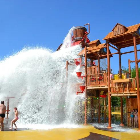 Parc aquatique pour enfants avec structure en bois et jets d'eau