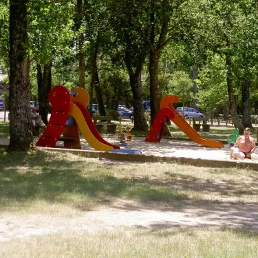 Parc d'attractions pour enfants au Camping Lou Puntaou, avec toboggans et sable.