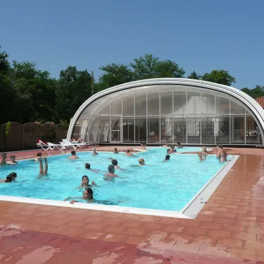 Piscine couverte avec personnes nageant au Camping Lou Puntaou