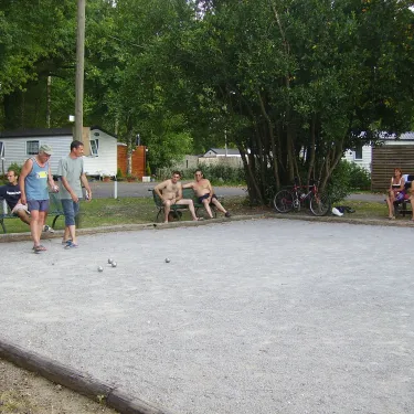 Camping Lou Puntaou : groupe de personnes jouant au boules sur une pelouse.