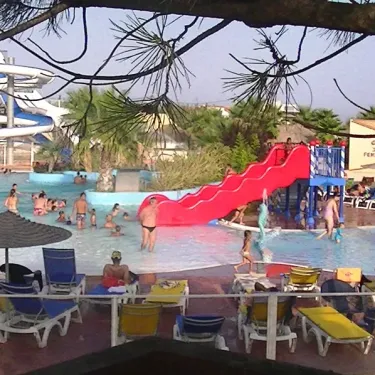 Camping La Plage et le Bord de Mer : piscine avec toboggan, chaises longues et enfants