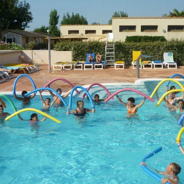 Camping La Plage et le Bord de Mer : groupe d'enfants faisant une activité aquatique avec des boules flottantes