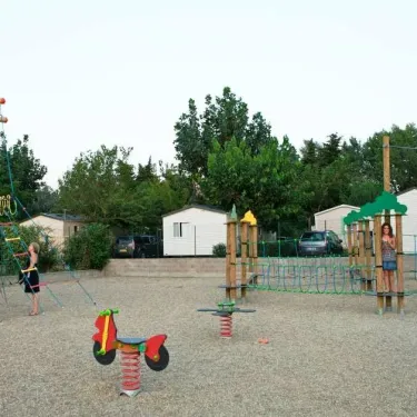 Enfants jouent sur un parc infantile au Camping Le Littoral
