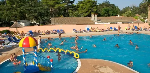 Camping Le Littoral : enfants jouent à l'eau près d'une structure ludique colorée dans la piscine.