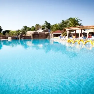 Piscine bleue avec toboggan et chaises longues au Camping Le Littoral