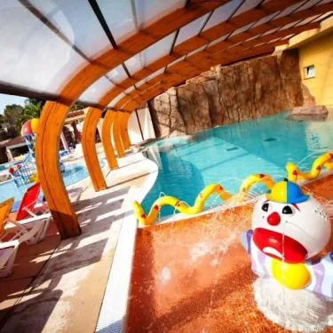 Piscine avec fontaine clown et chaises longues au Camping Le Littoral
